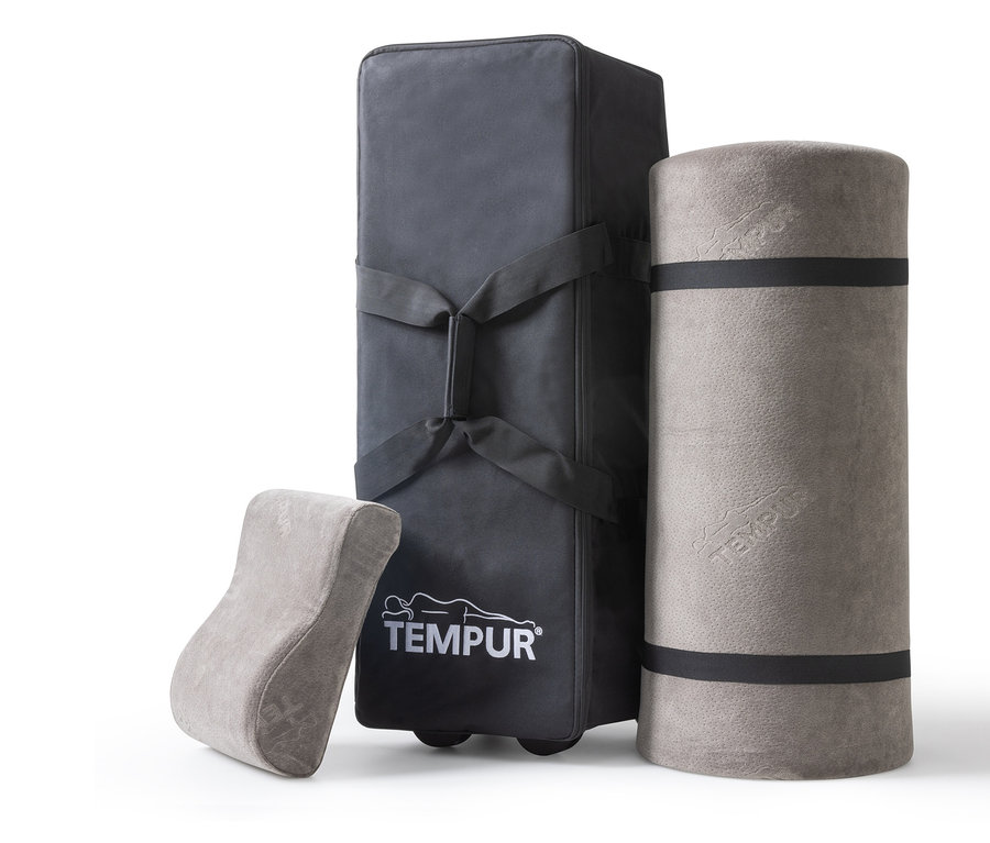 Graues TEMPUR® Reiseset, bestehend aus einer Tragetasche, einer zusammengerollten Matratze und einem Lordosekissen.