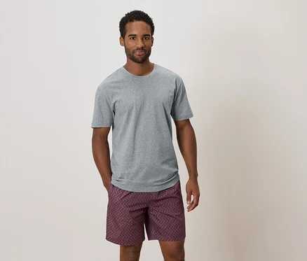 Homme portant un t-shirt gris et un short à motifs