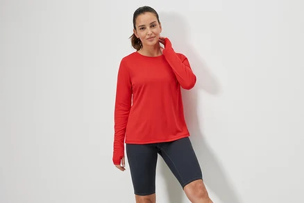 Femme posant dans un t-shirt technique rouge.