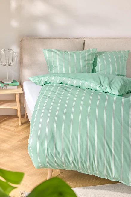 Lit avec linge de lit en microfibre vert clair, taille standard et king size, avec des rayures blanches.