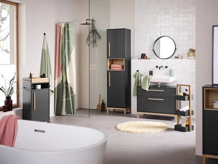 Intérieur de salle de bain avec lavabo, miroir et meubles de salle de bain Eklund anthracite. Une baignoire est au premier plan.