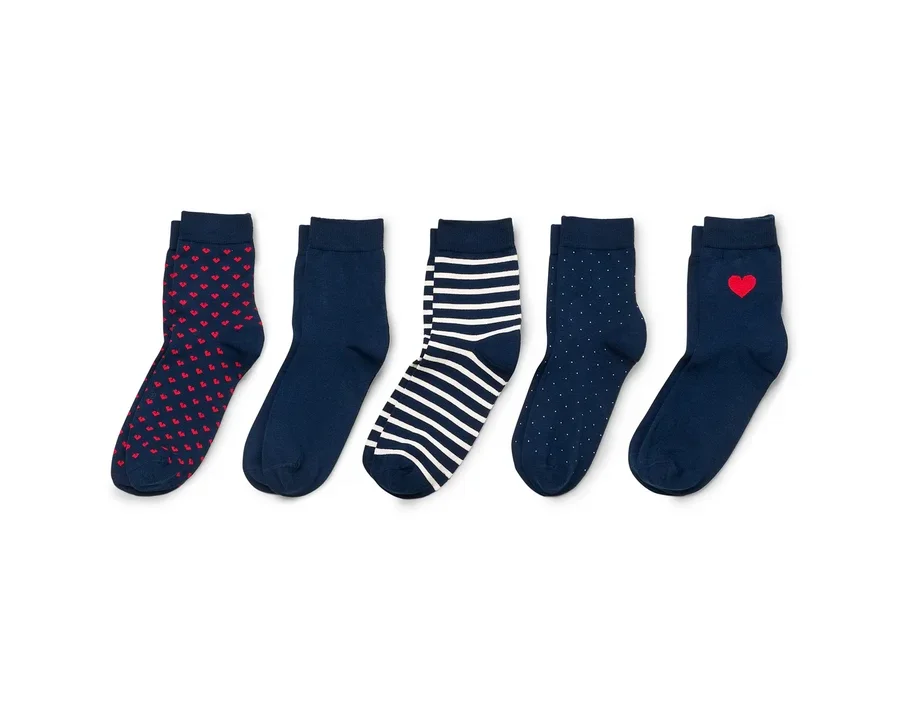 Cinq paires de chaussettes bleu marine avec des cœurs rouges, des rayures et des pois sur fond blanc.