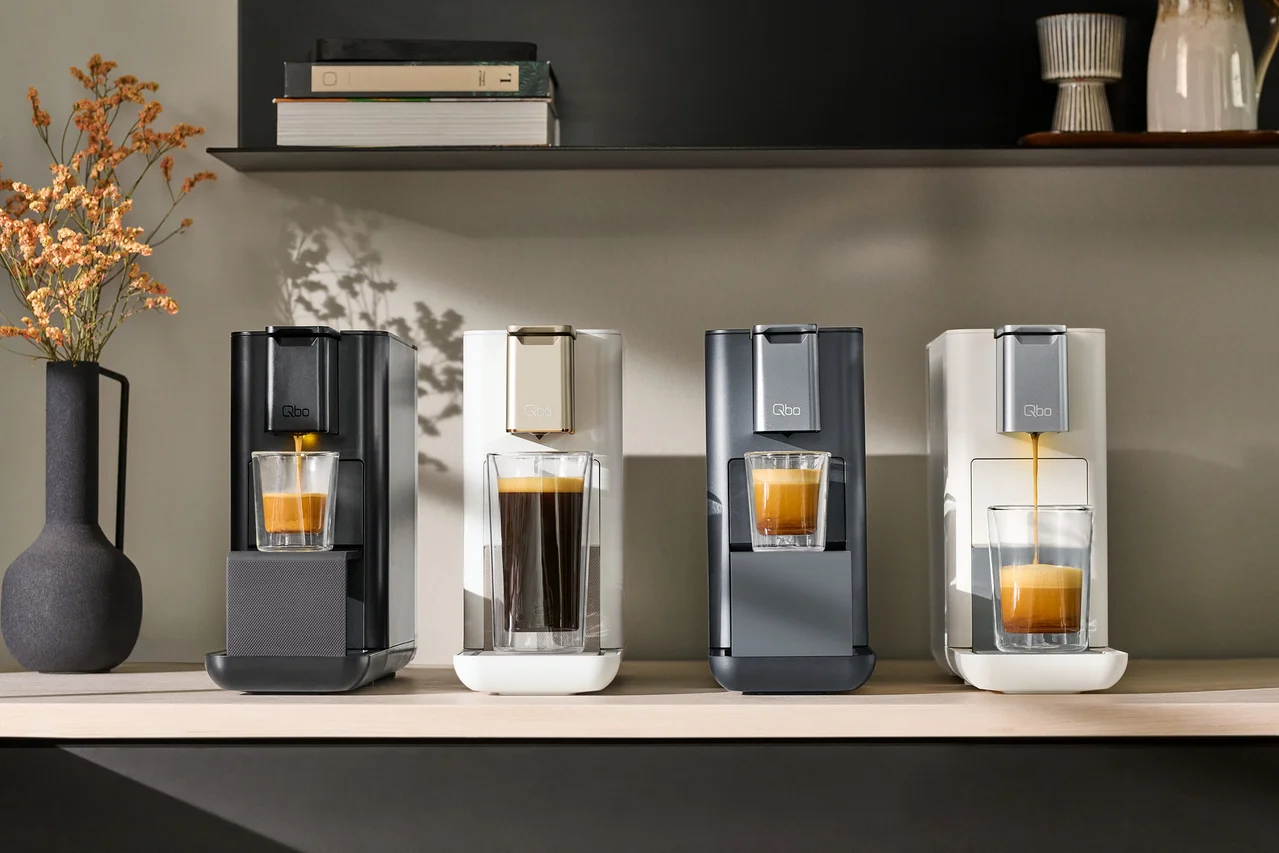 Quatre machines à café sont alignées sur une étagère.