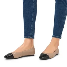 Beine in Jeans und Leder-Ballerinas.