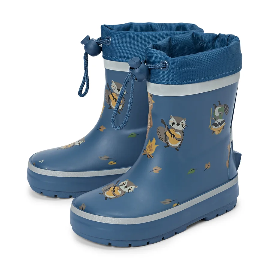 Une paire de bottes en caoutchouc bleues avec cordon de serrage et motifs de raton laveur se tient sur un fond blanc.