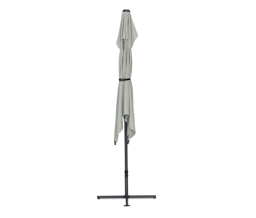 Un demi-parasol gris plié avec un tissu enroulé et une sangle noire.
