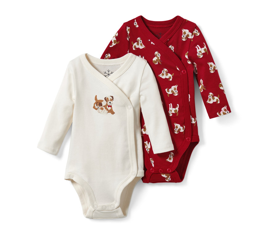Deux bodys pour bébé : un crème avec un motif de chiens, l'autre rouge avec un imprimé de chiens.