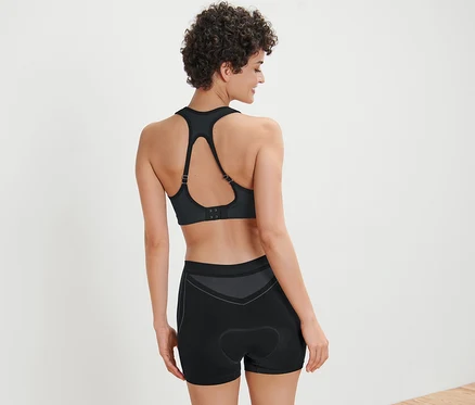 Femme vue de dos portant un soutien-gorge de sport et un boxer de vélo.