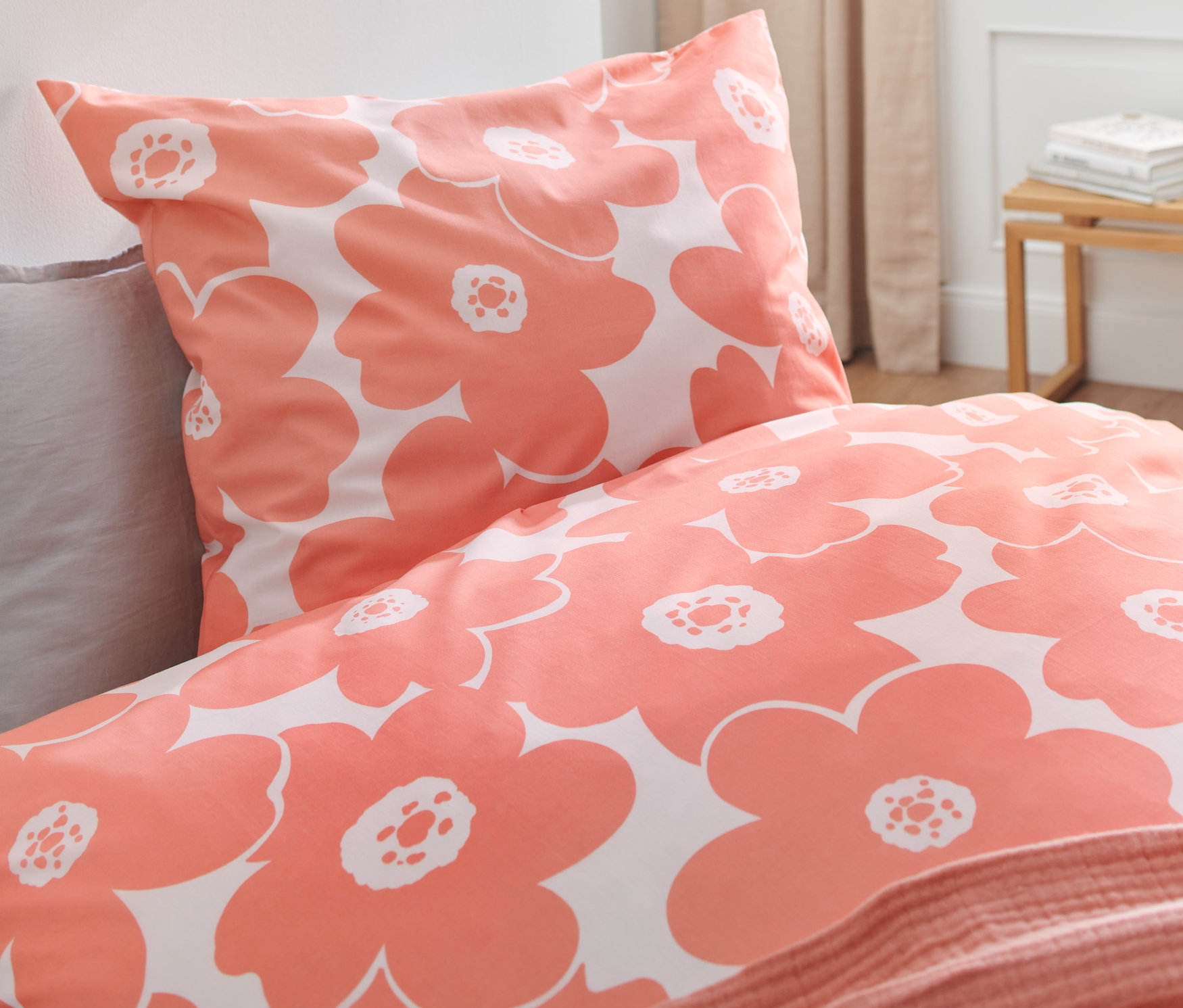 Gros plan d'une parure de lit corail à motif floral, comprenant une parure de lit en coton de qualité supérieure de taille standard et grande taille.