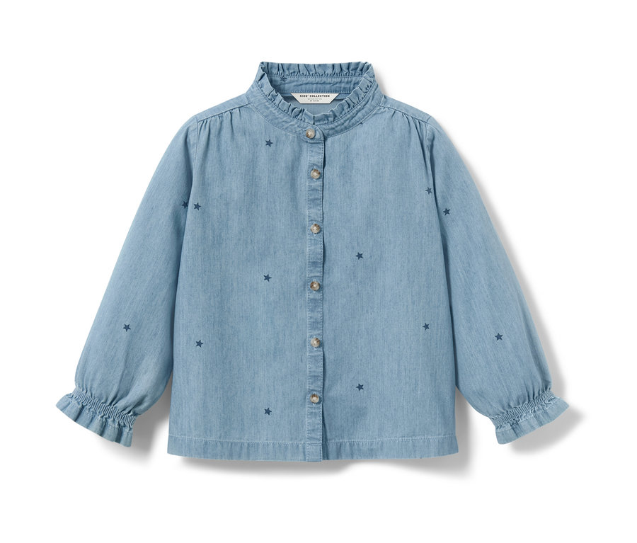 Chemisier en chambray bleu clair pour enfant avec étoiles et manches longues.
