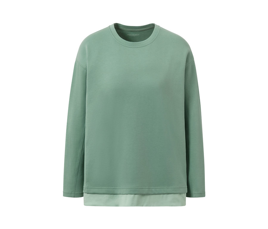 Un haut de fitness oversize à manches longues vert sur fond blanc.