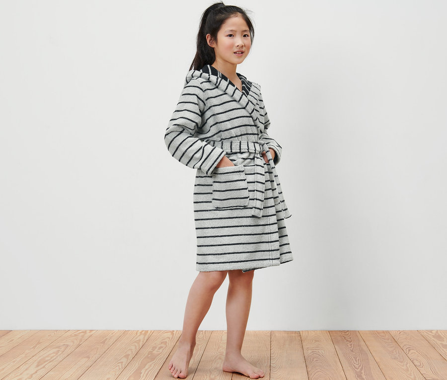 Fille portant un peignoir pour enfant avec des rayures grises et noires.