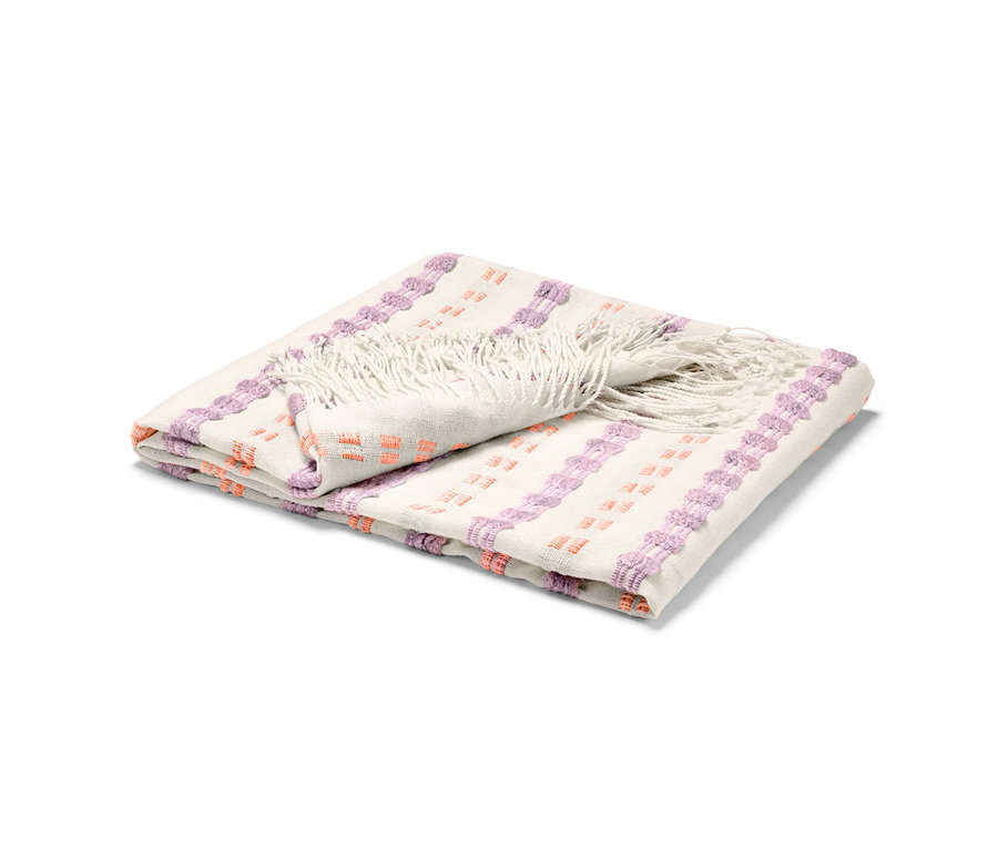 Couverture pliée avec des franges et des motifs violets et orange.