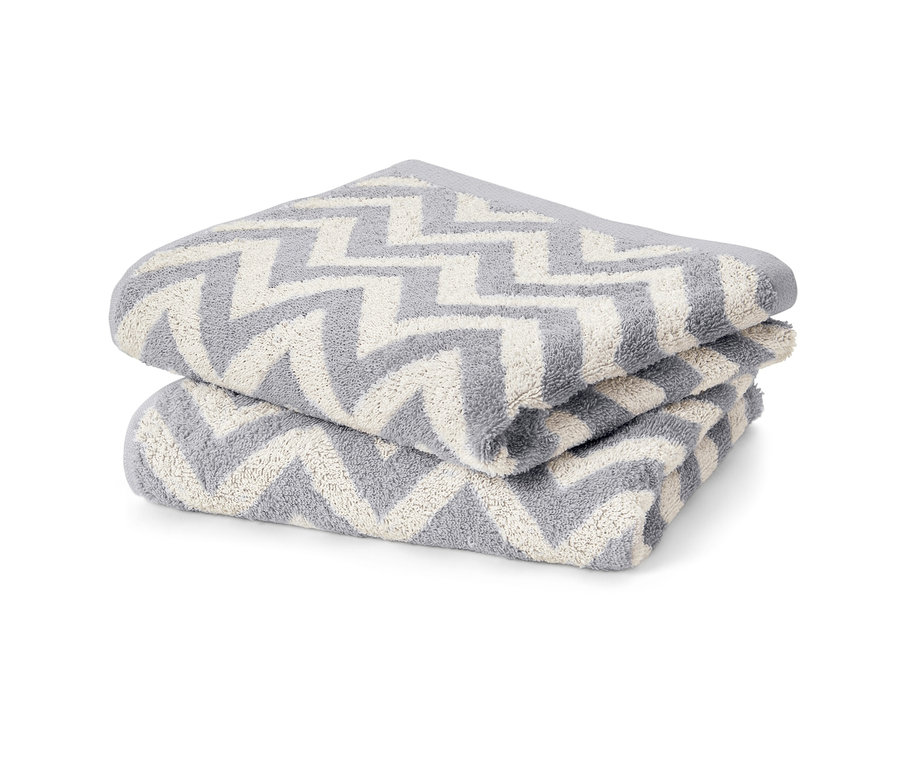 Deux torchons en jacquard gris avec un motif zigzag blanc empilés l'un sur l'autre.