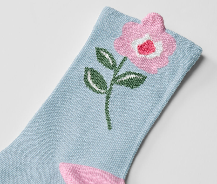 Gros plan d'une chaussette pour enfant avec un motif floral.