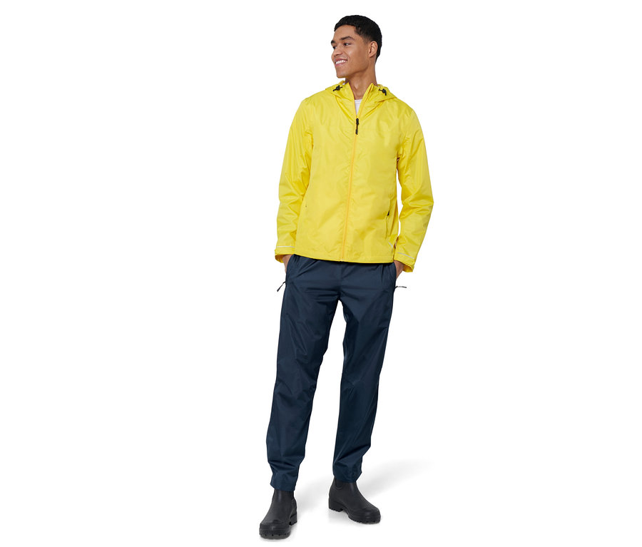 Un homme porte une veste jaune et un pantalon de pluie unisexe.