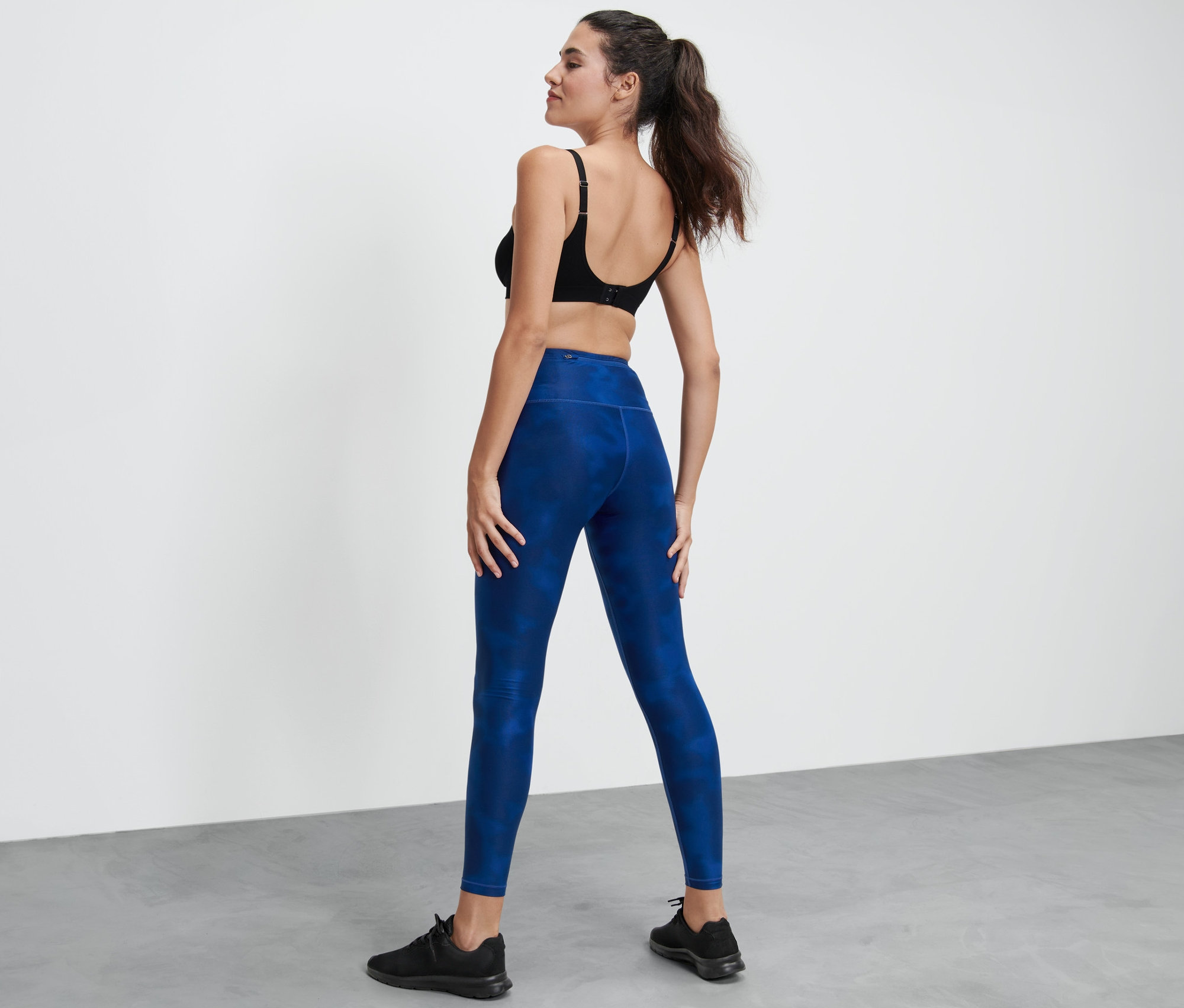 Femme debout, dos à la caméra, portant un legging de sport.