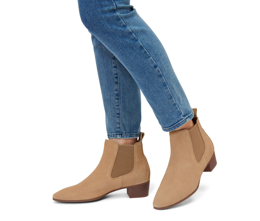 Jambes en jean bleu et bottines en daim.
