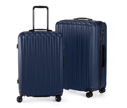 Un lot de valises rigides, grande et petite, bleu marine, debout sur un fond blanc.