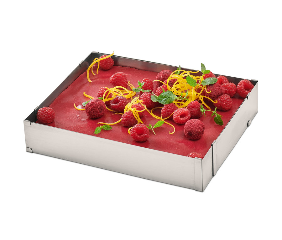 Cadre à pâtisserie carré en acier inoxydable avec framboises, zeste de citron et menthe.