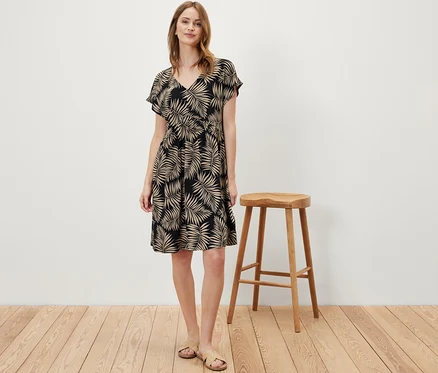 Une femme debout portant une robe en jersey imprimée.