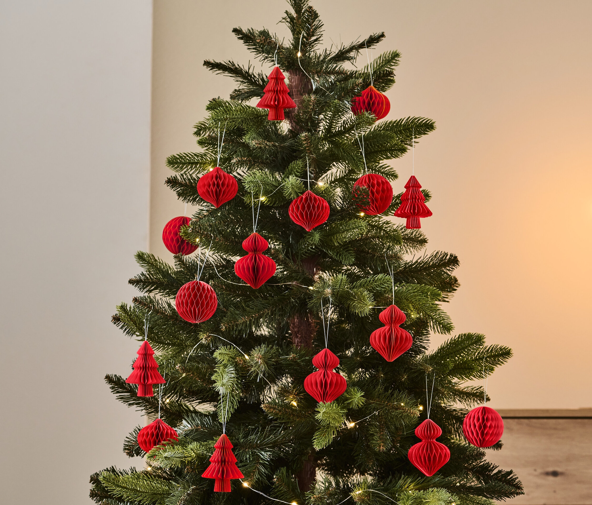 Sapin de Noël décoré avec un ensemble de 4 décorations rouges.