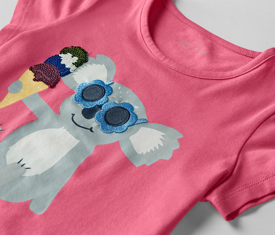 Gros plan sur un t-shirt rose avec un koala portant des lunettes de soleil et une glace.