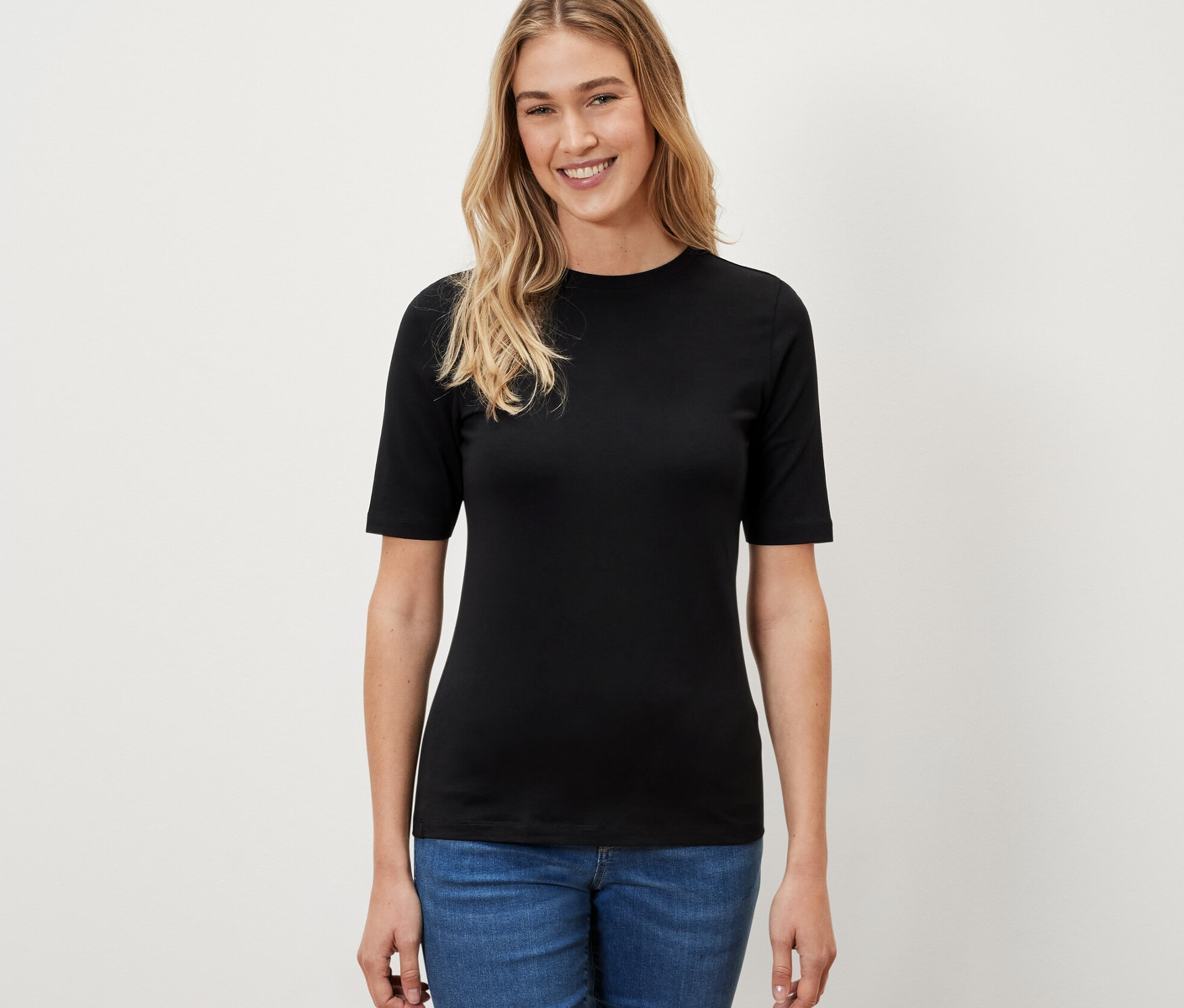 Femme portant un t-shirt noir à manches courtes.