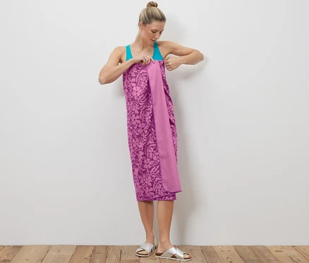 Femme enroulant un linge de toilette outdoor violet autour de son corps.