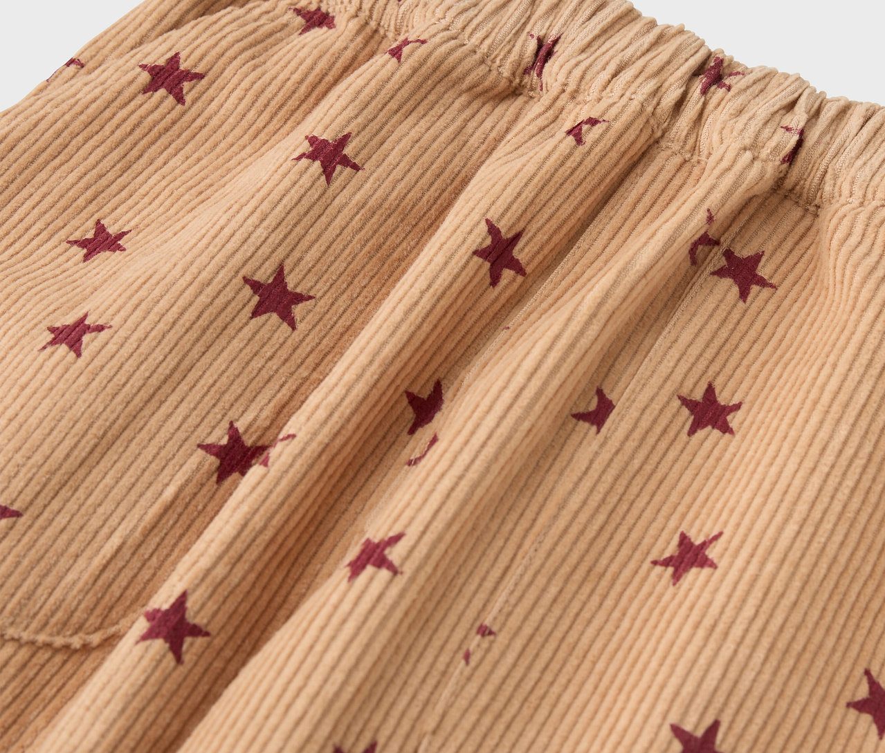 Gros plan sur le pantalon marron à enfiler en velours pour enfant, avec des étoiles.