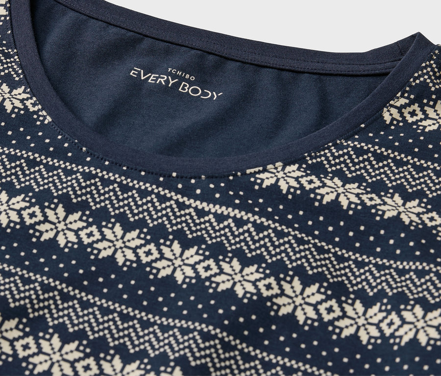 Détail d'un t-shirt bleu marine avec un motif norvégien blanc.