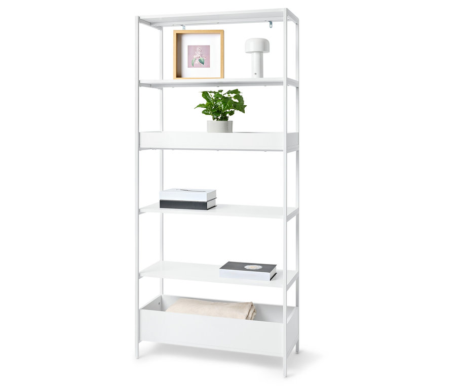 Étagère blanche à cinq niveaux avec une plante, un cadre photo, une lampe, deux boîtes et une couverture.