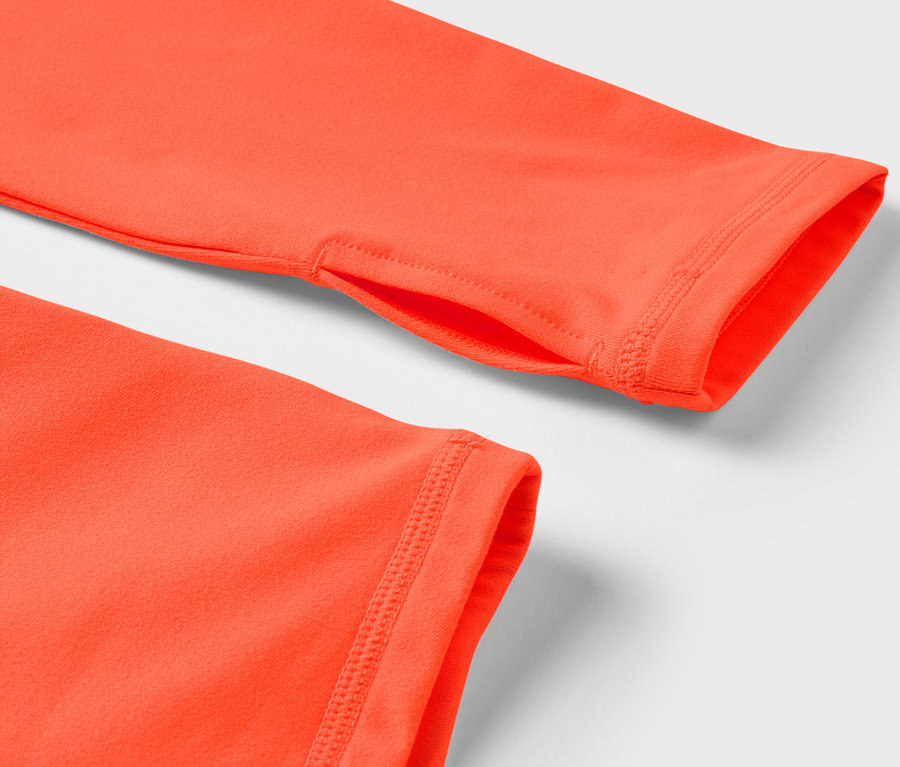 Gros plan sur un t-shirt orange à manches longues avec un trou pour le pouce.