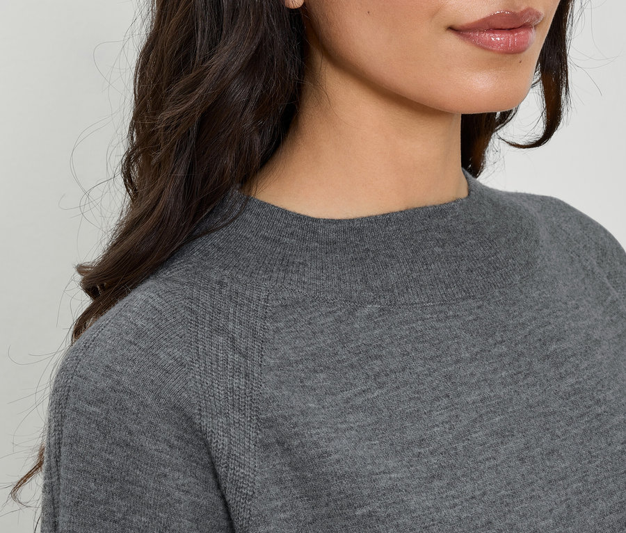 Gros plan d'un pull gris à manches longues et col rond pour femme.