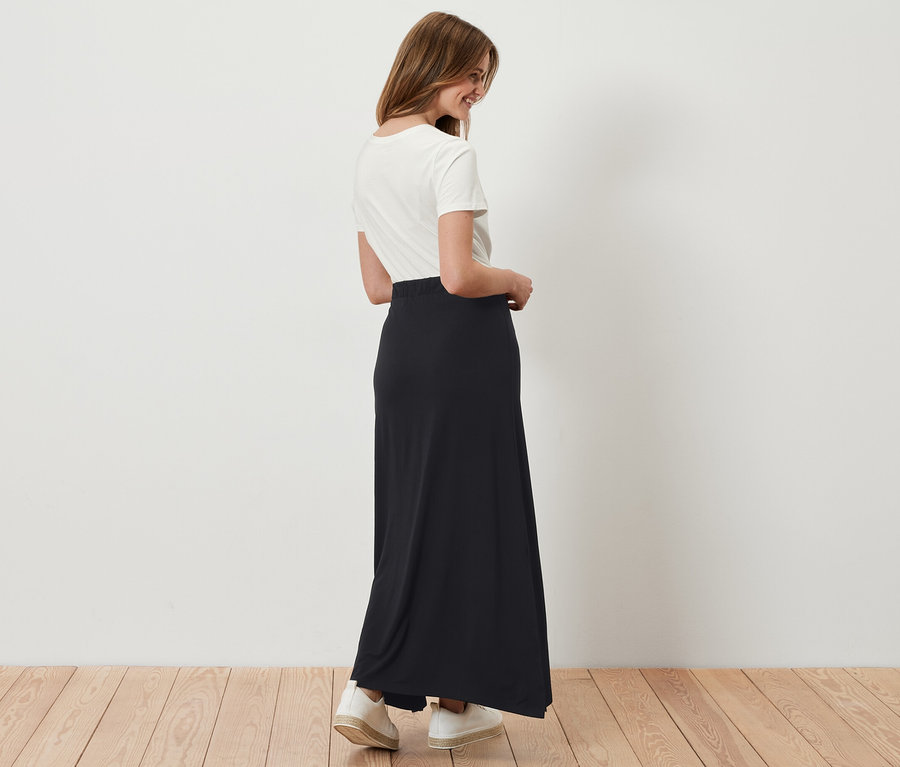 Femme portant une jupe longue en jersey noire.