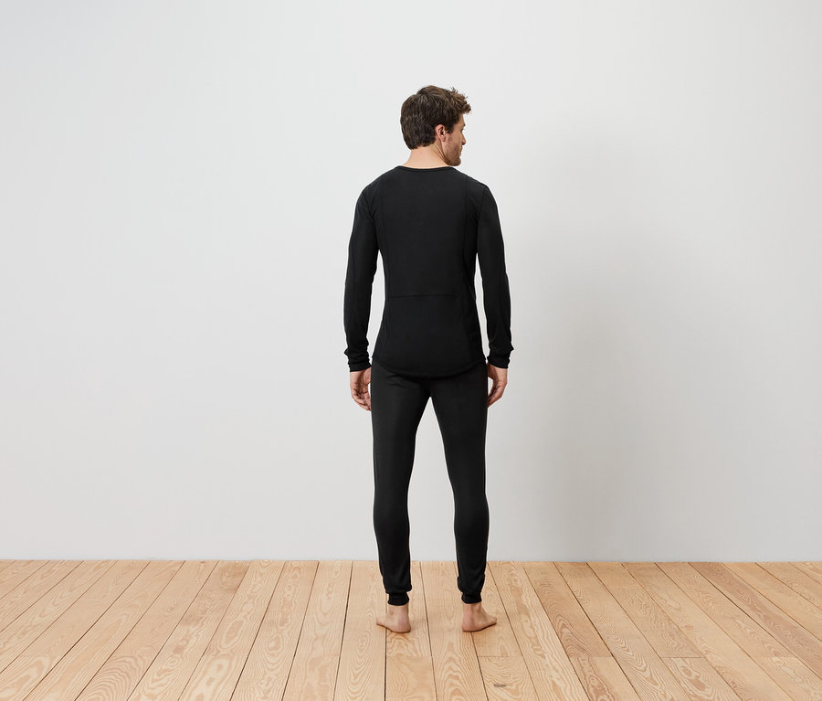 Un homme, vu de dos, porte un ensemble de sous-vêtements thermiques noirs.