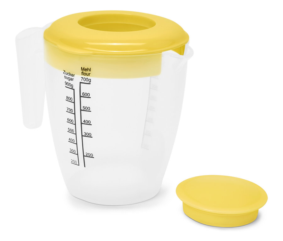 Un verre mesureur transparent avec un couvercle jaune et des marquages de mesure.