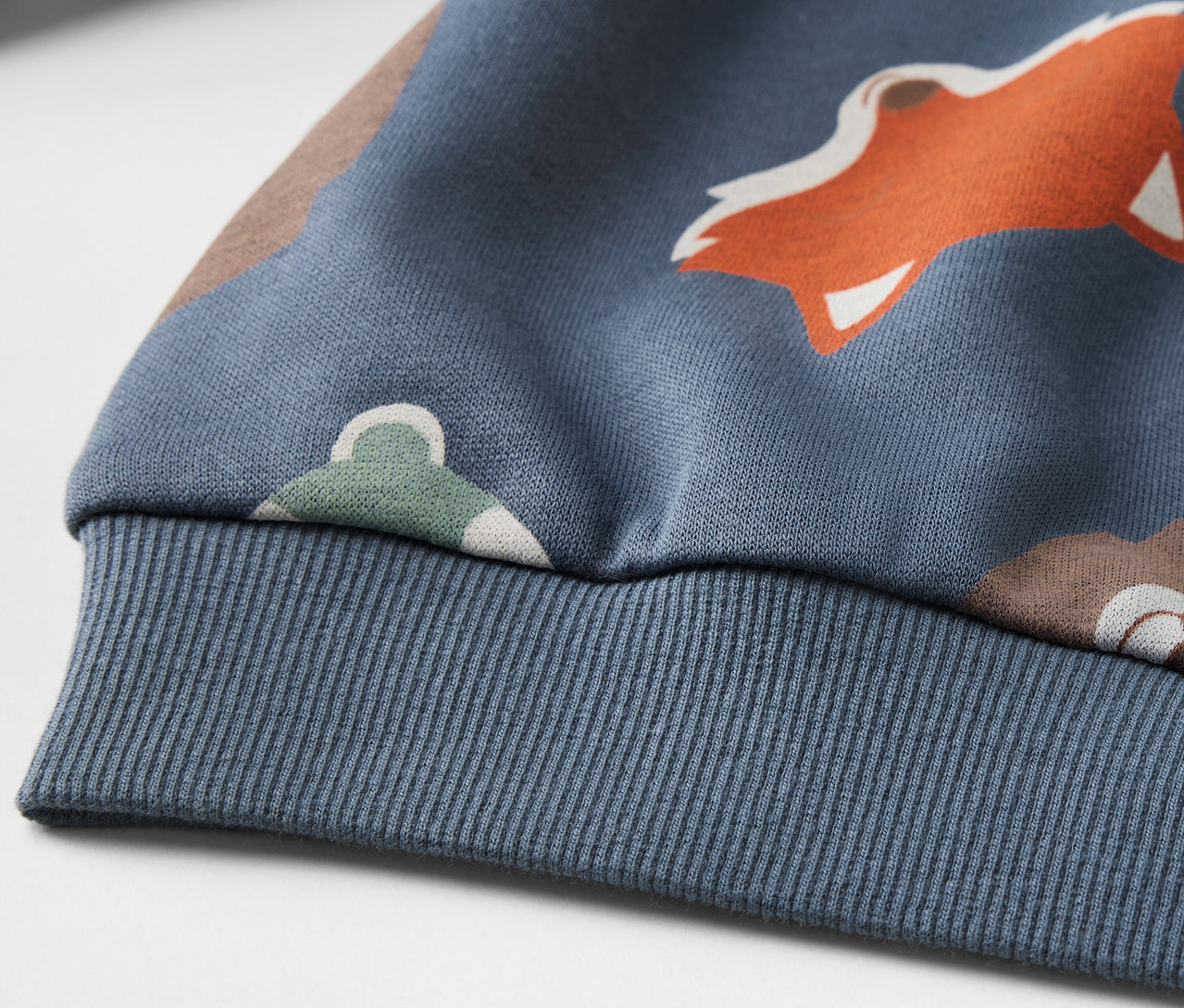 Détail d'un sweat-shirt enfant bleu avec motif renard.