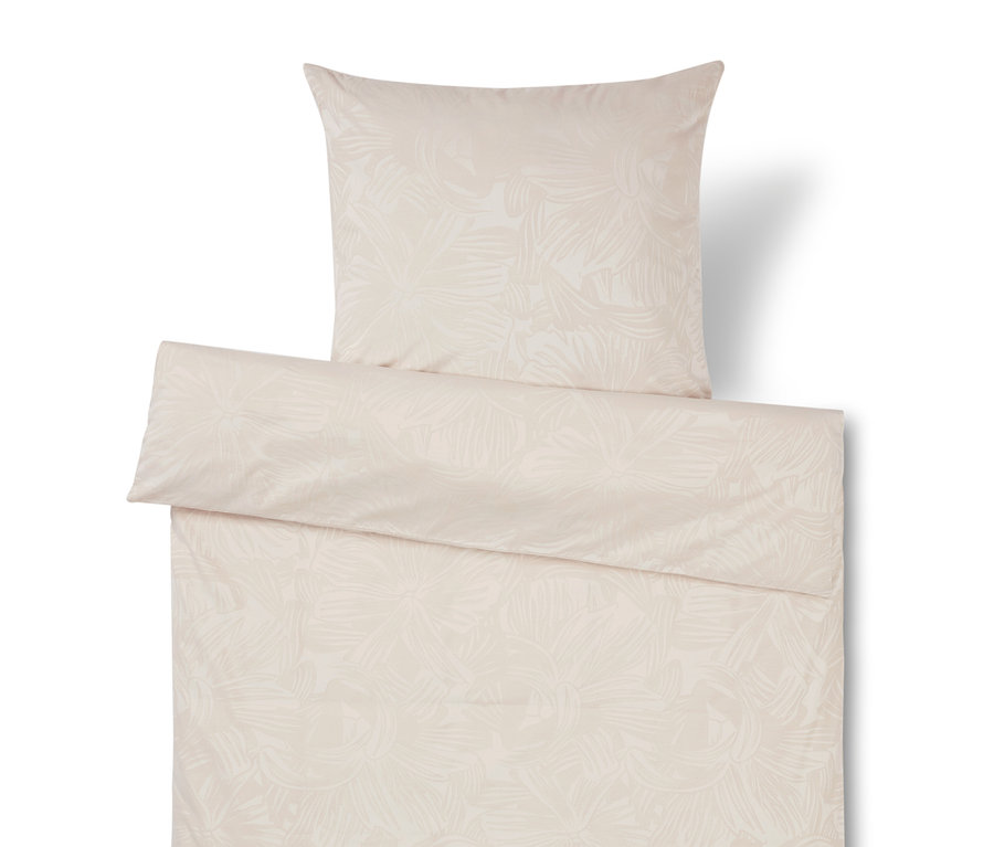 Linge de lit beige avec motif de feuilles, incluant un oreiller.