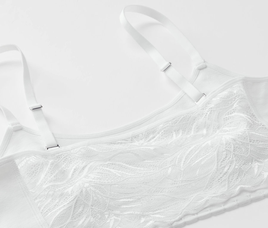Détail d'une brassière blanche sans coutures avec de la dentelle.
