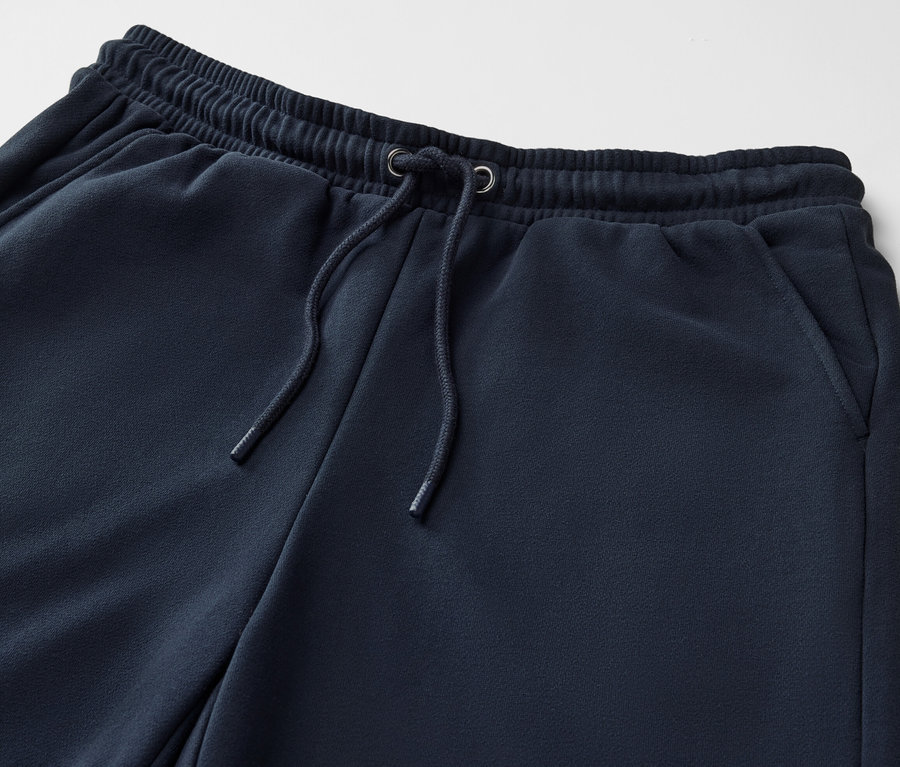 Gros plan sur un pantalon de jogging bleu foncé avec cordon de serrage.