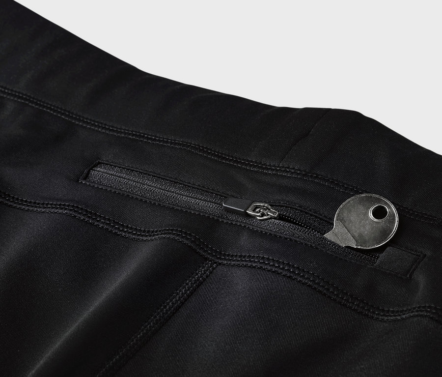 Détail de leggings noirs avec une poche zippée et une clé.