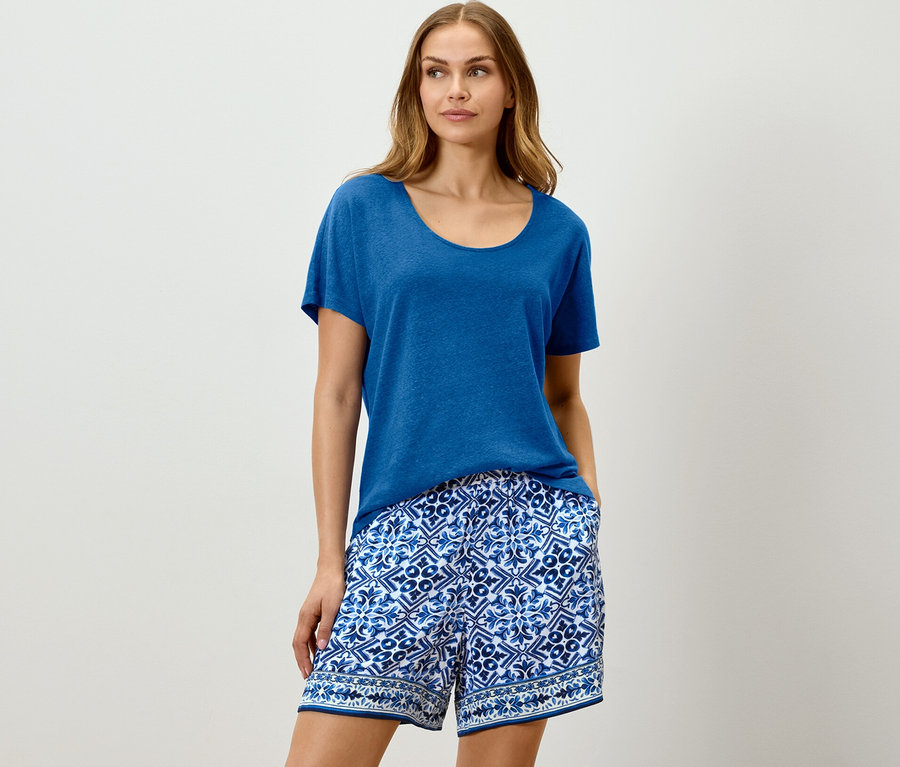 Femme portant un t-shirt en lin mélangé bleu cobalt et un short à motifs bleus.