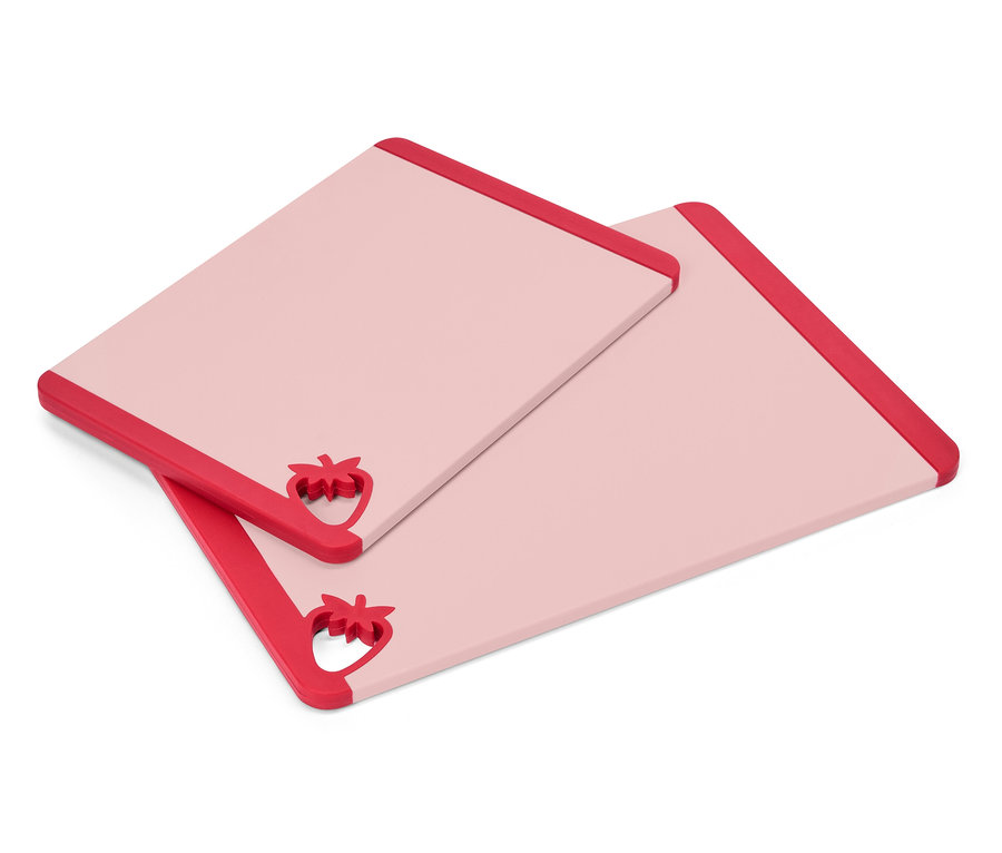 Deux planches à découper rectangulaires roses avec des accents de fraises rouges sur un coin sont posées l'une sur l'autre.