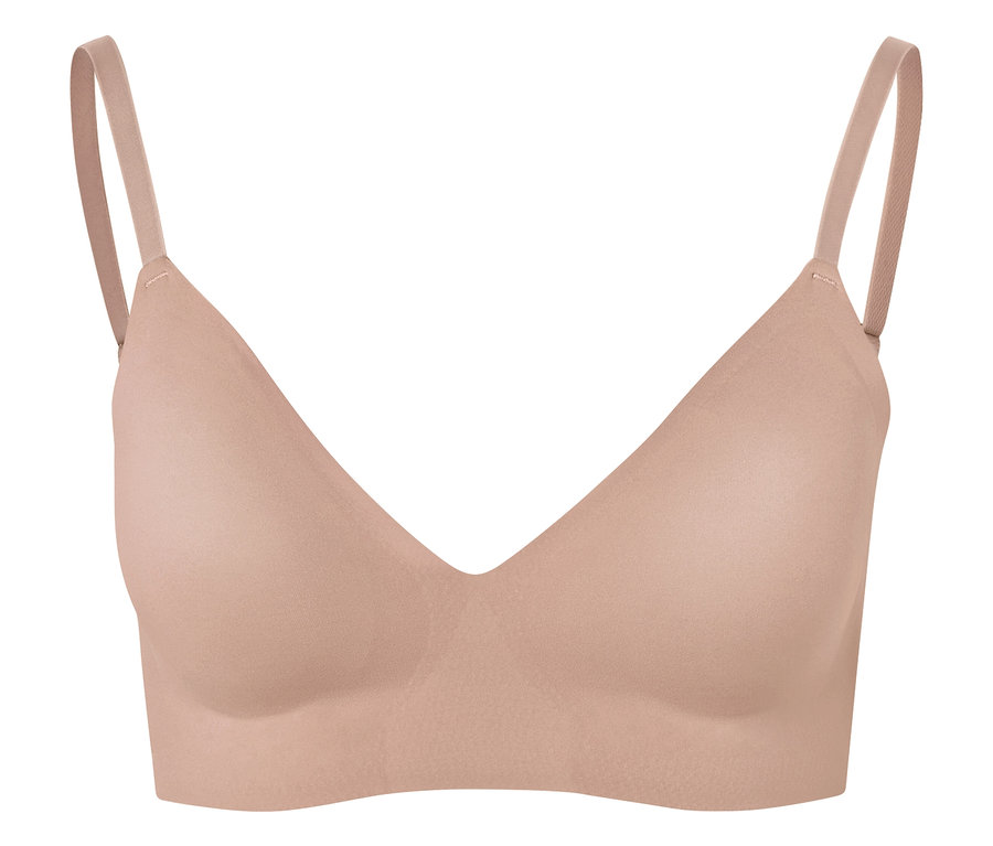 Gros plan d'un soutien-gorge couleur chair à fines bretelles sur fond blanc.