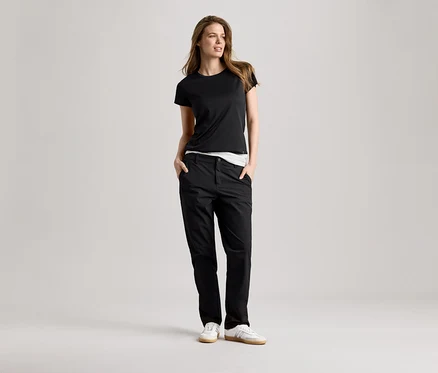 Femme portant un t-shirt de sport noir et un pantalon. Le t-shirt de sport est noir.