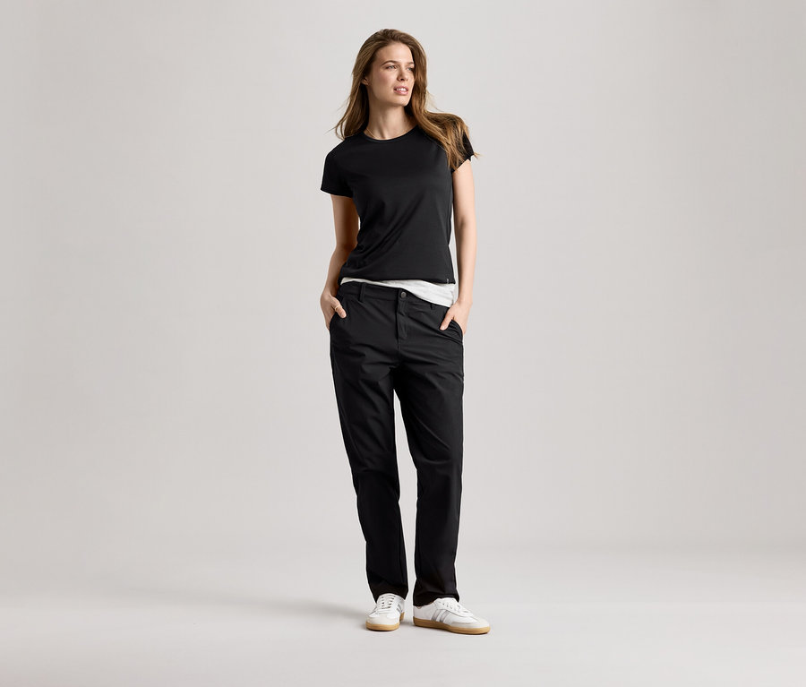 Femme portant un t-shirt de sport noir et un pantalon. Le t-shirt de sport est noir.