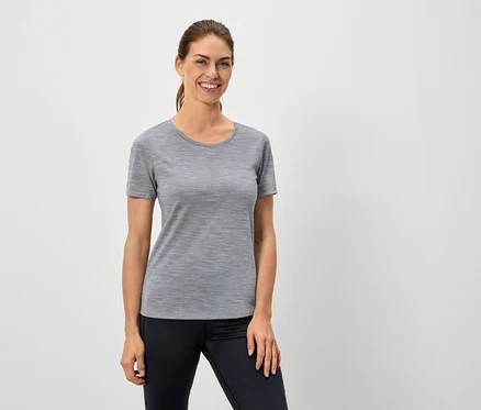 Femme portant un t-shirt gris et un legging noir.