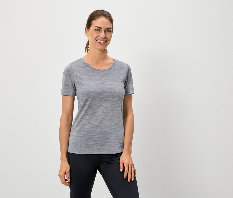 Femme portant un t-shirt gris et un legging noir.