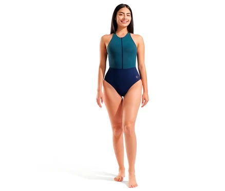 Femme debout pieds nus en maillot de bain bleu-vert sur fond blanc.